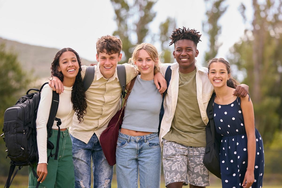 Diverse group of students with backpacks smiling together