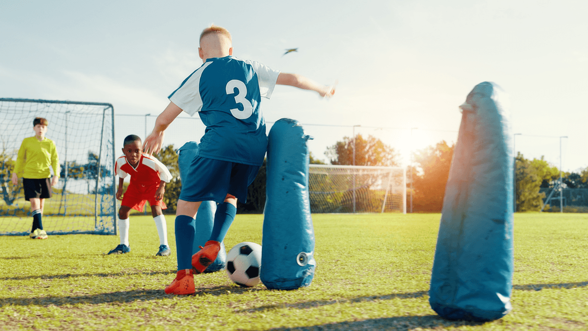 Young soccer players training on a field at sunset